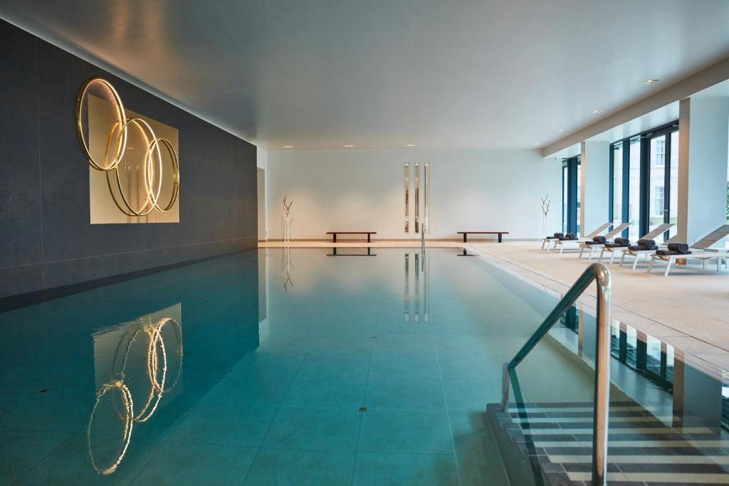 a swimming pool in a building with stairs and a pool at Rudding Park in Harrogate
