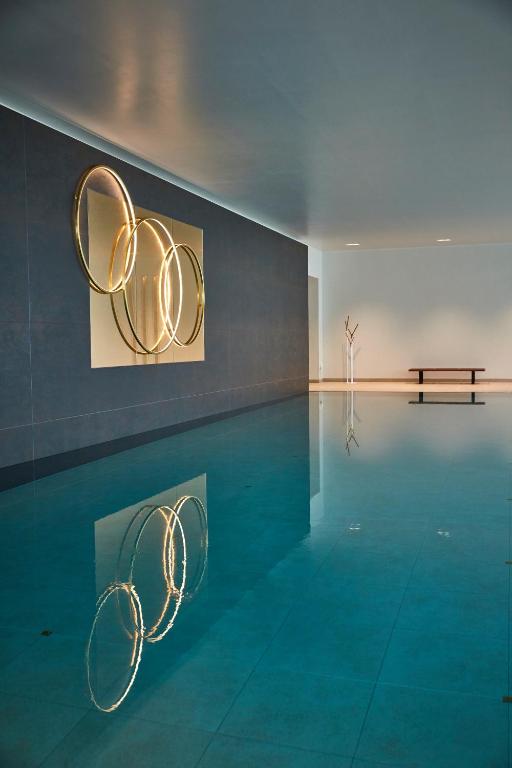 a swimming pool with a bench in a room at Rudding Park in Harrogate