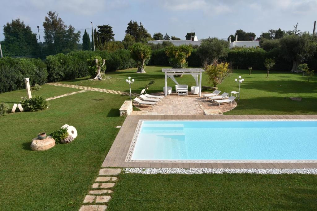un patio trasero con piscina y jardín en Villa Carrubo Peroscia by STHEY, en Padresergio