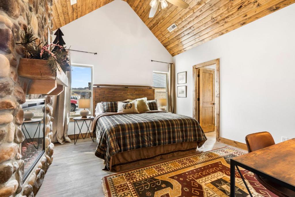 a bedroom with a bed and a stone wall at New Log Cabin with Ozark Sunset Views, $400 Daily Activities Included, Pickleball in Branson