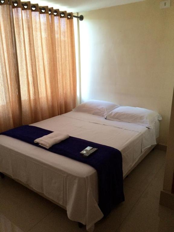 a bedroom with a bed with a blue blanket at Pousada Verdes Flores in Brasilia