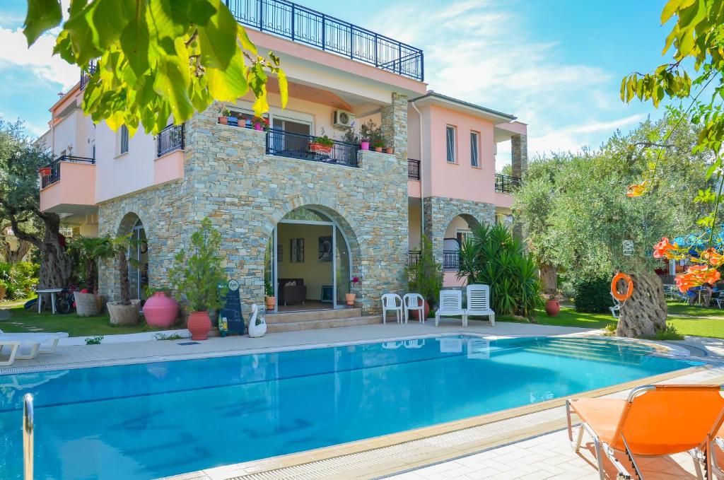 a villa with a swimming pool in front of a house at Villa Eden in Limenas