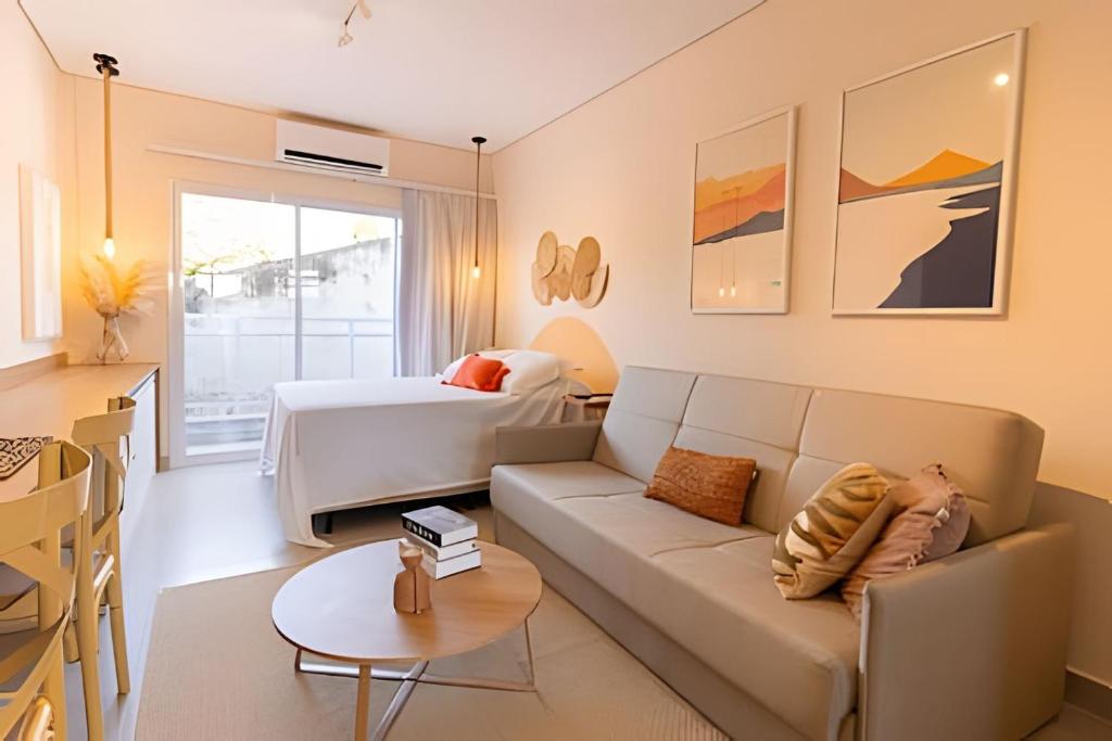 a living room with a couch and a bed at Pousada na praia Peruibe - Vila Thaynara in Peruíbe