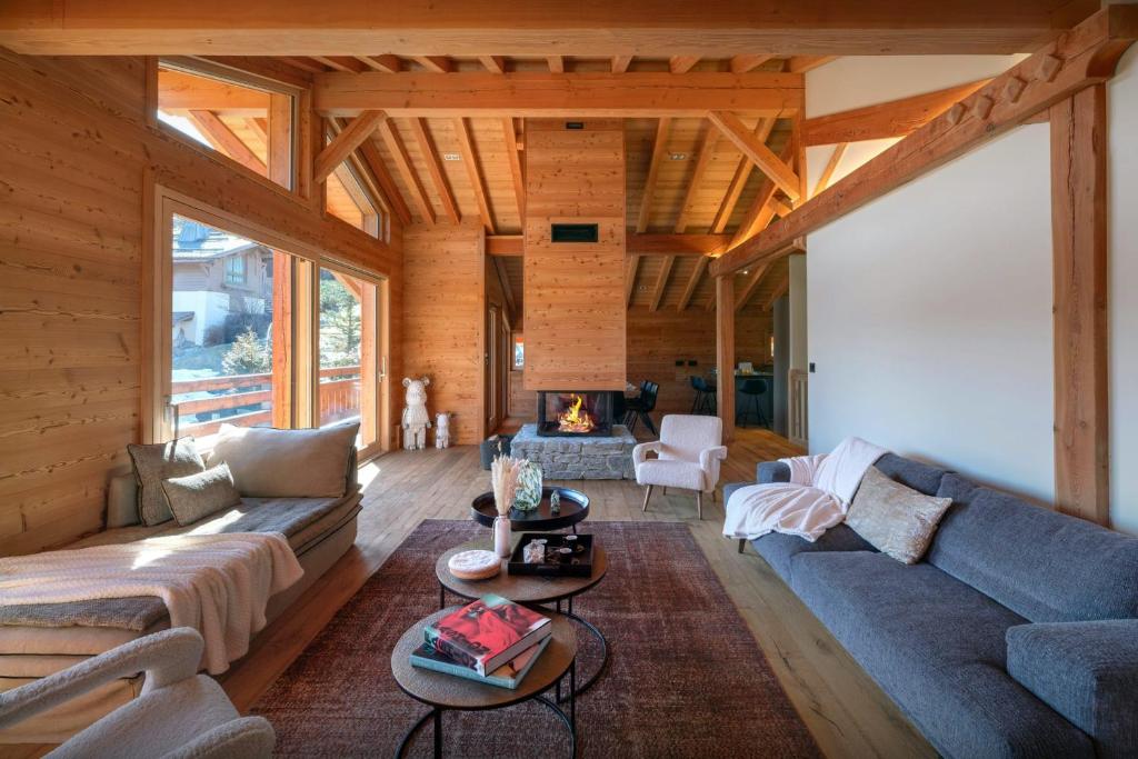 a living room with a couch and a fireplace at Chalet Ellambra - OVO Network in Combloux