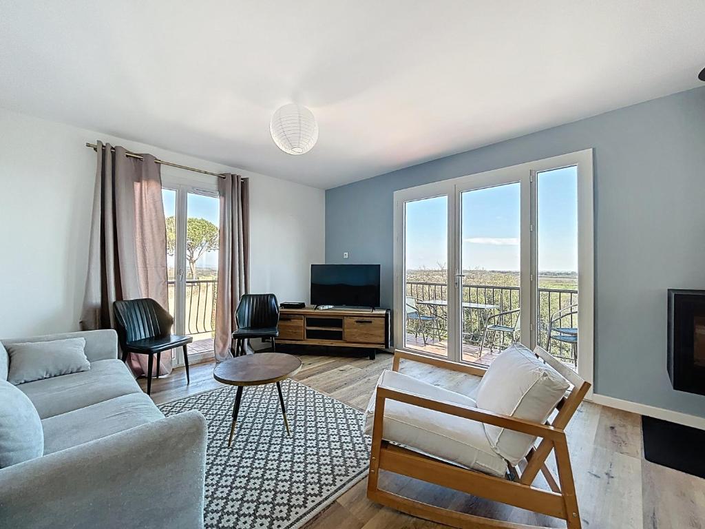 un salon avec un canapé et une télévision dans l'établissement 3160-Maison avec piscine avec 8 couchages, à Banyuls-dels-Aspres