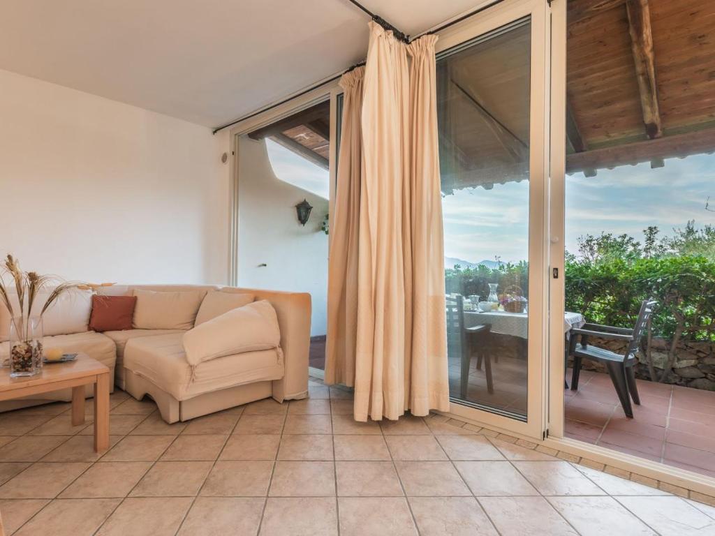 a living room with a couch and a sliding glass door at Capo Ceraso Family Resort in Costa Corallina