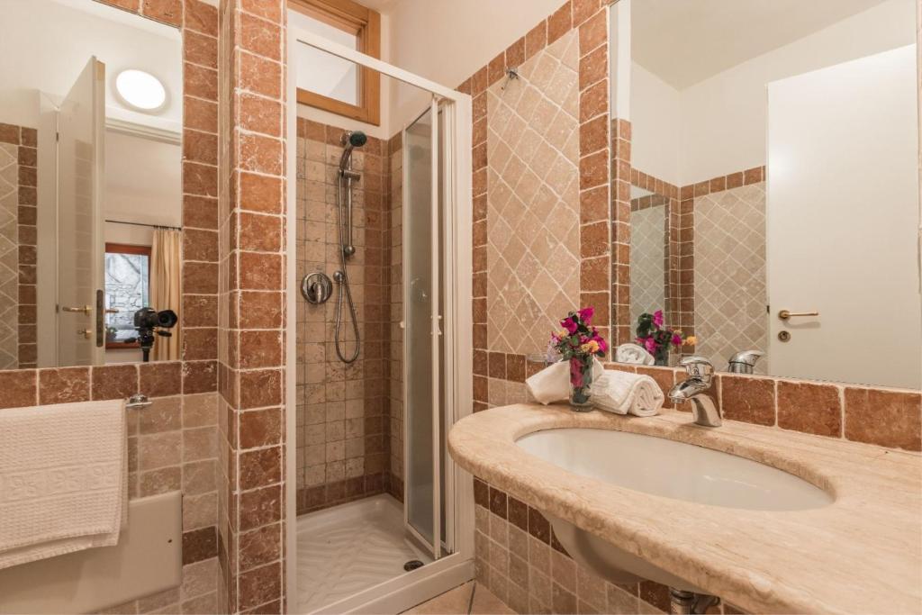 a bathroom with a sink and a shower at Capo Ceraso Family Resort in Costa Corallina