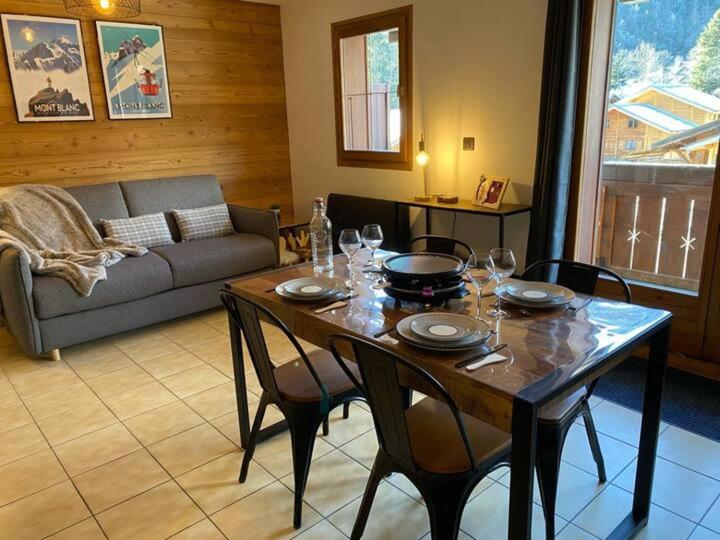 un salon avec une table, des chaises et un canapé dans l'établissement Le Cocon des Cîmes, aux Contamines-Montjoie