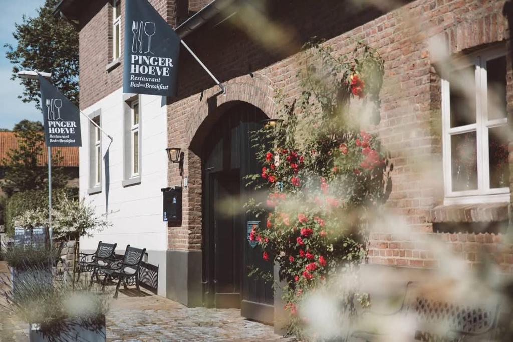 een bakstenen gebouw met bloemen aan de zijkant bij De Pingerhoeve in Nuth