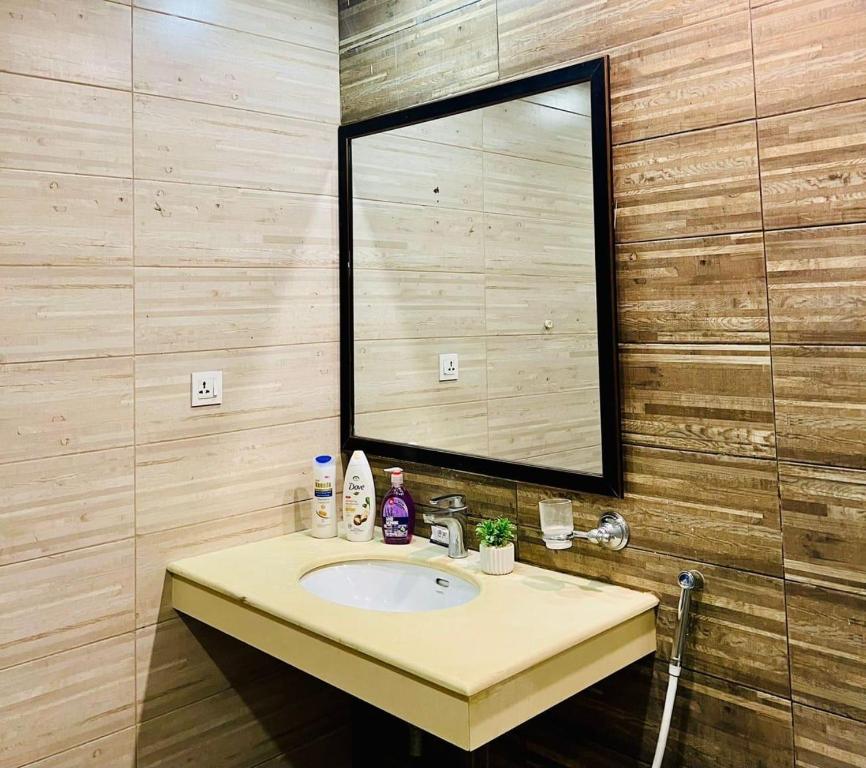 a bathroom with a sink and a large mirror at Deluxe suite in bahria heights 1 rawalpindi in Rawalpindi
