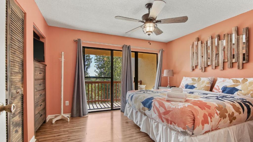 a bedroom with a large bed and a balcony at 5 minutes walk to beach, Family Friendly condo with shared pool, tennis court in Panama City Beach