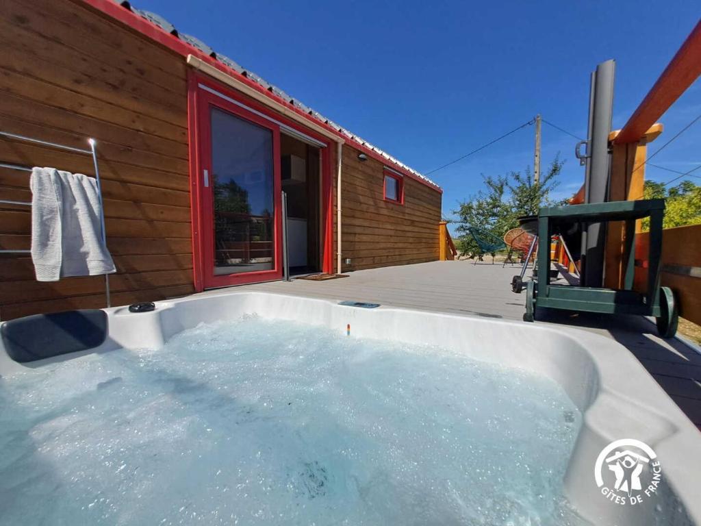 Castelnau-de-MontmiralにあるLa roulotte du tonnelierの家の前のホットタブ