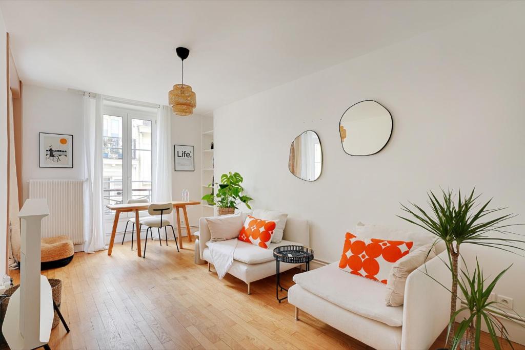 un salon avec des meubles blancs et une table dans l'établissement Charmant 2P à Paris, rue Rodier - Proche de l'Opéra Garnier, à Paris