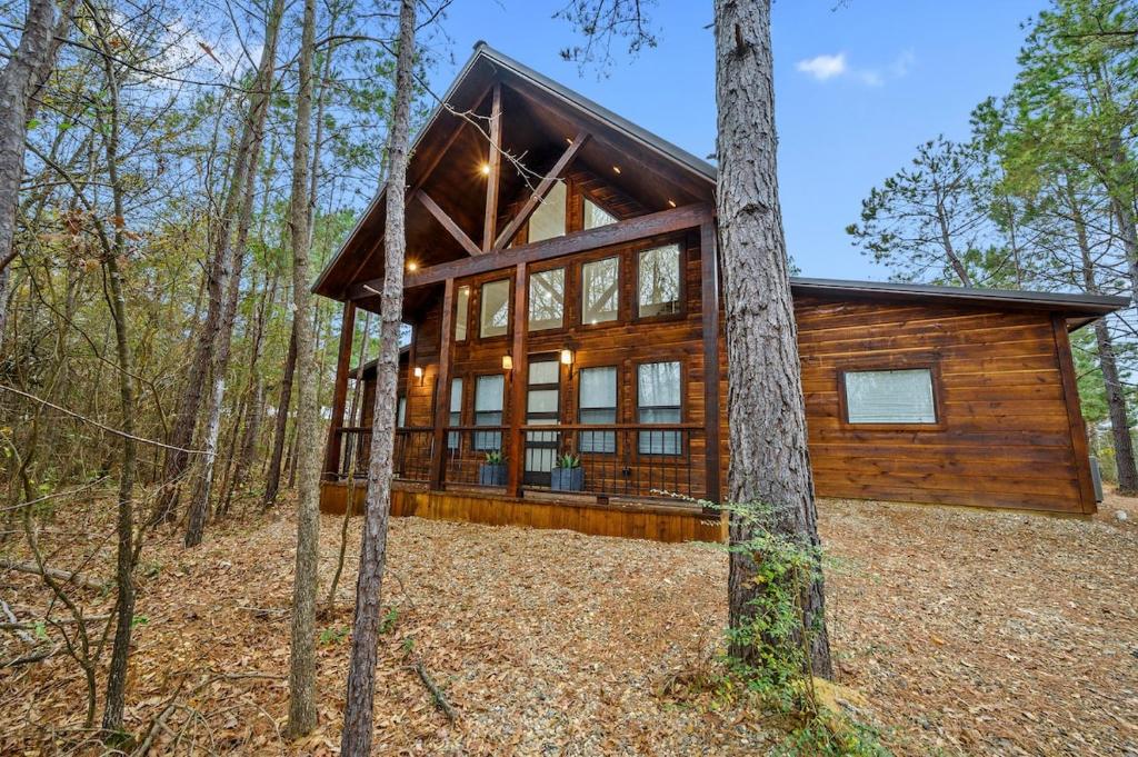 une cabane en rondins entourée d'arbres dans l'établissement The Modern Luxurious Mystic Love Cabin, à Broken Bow