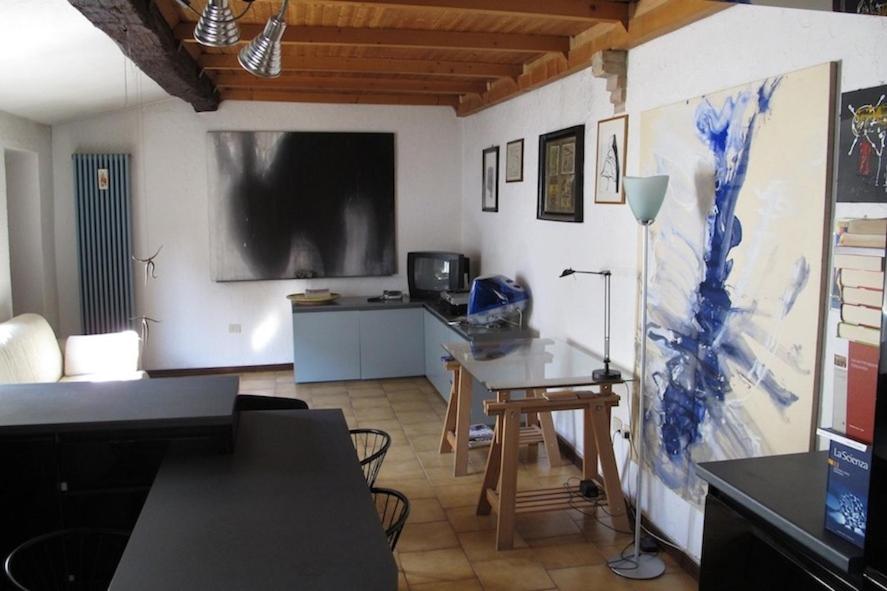 een woonkamer met een tafel en een tv aan de muur bij Il Balcone Holiday House in Parma