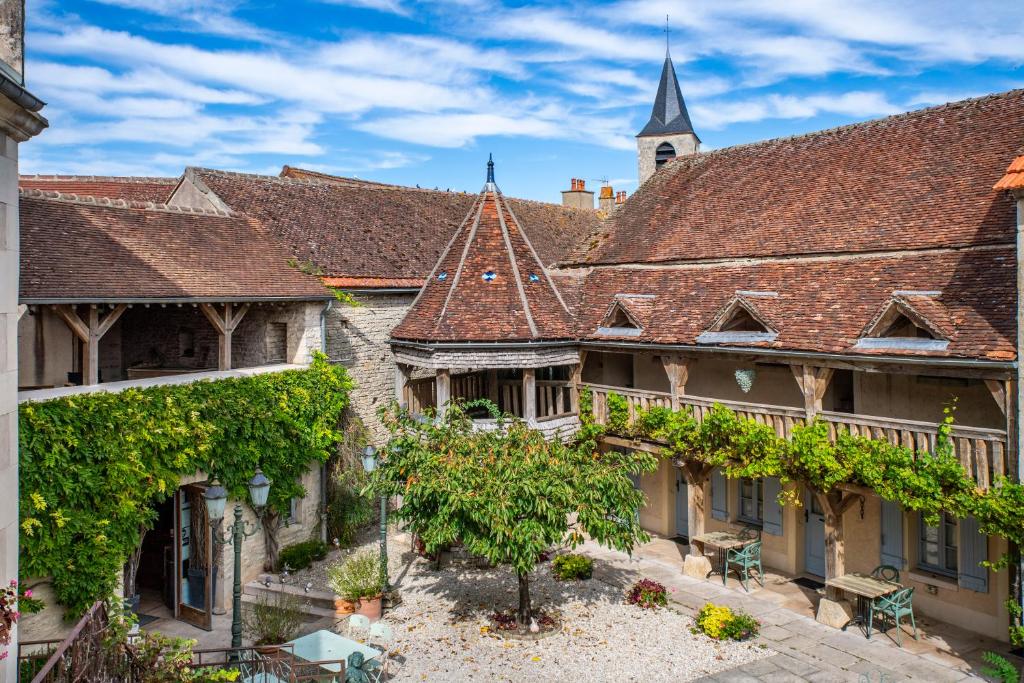 an old town with a church in the background at Hôtel De La Beursaudiere in Nitry