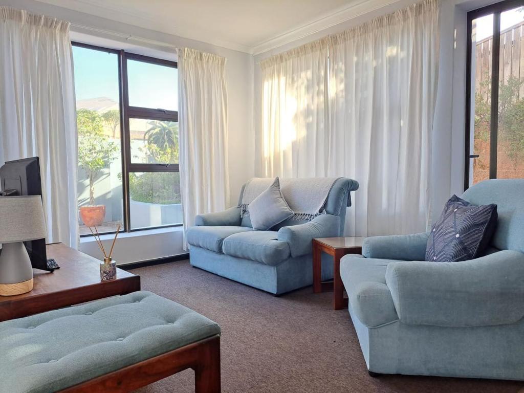 un salon avec deux chaises et un canapé dans l'établissement Be'landre Courtyard Cottage, au Cap