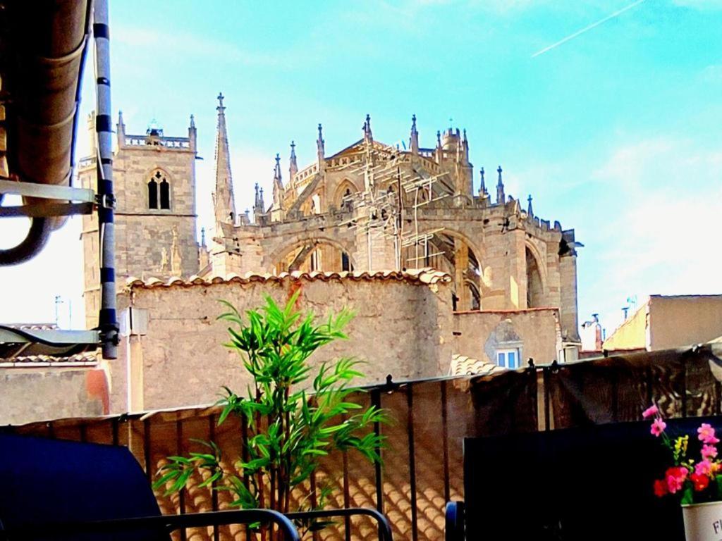 une ancienne église avec une cathédrale en arrière-plan dans l'établissement T2 Duplex avec Terrasse vue Cathédrale, à Narbonne
