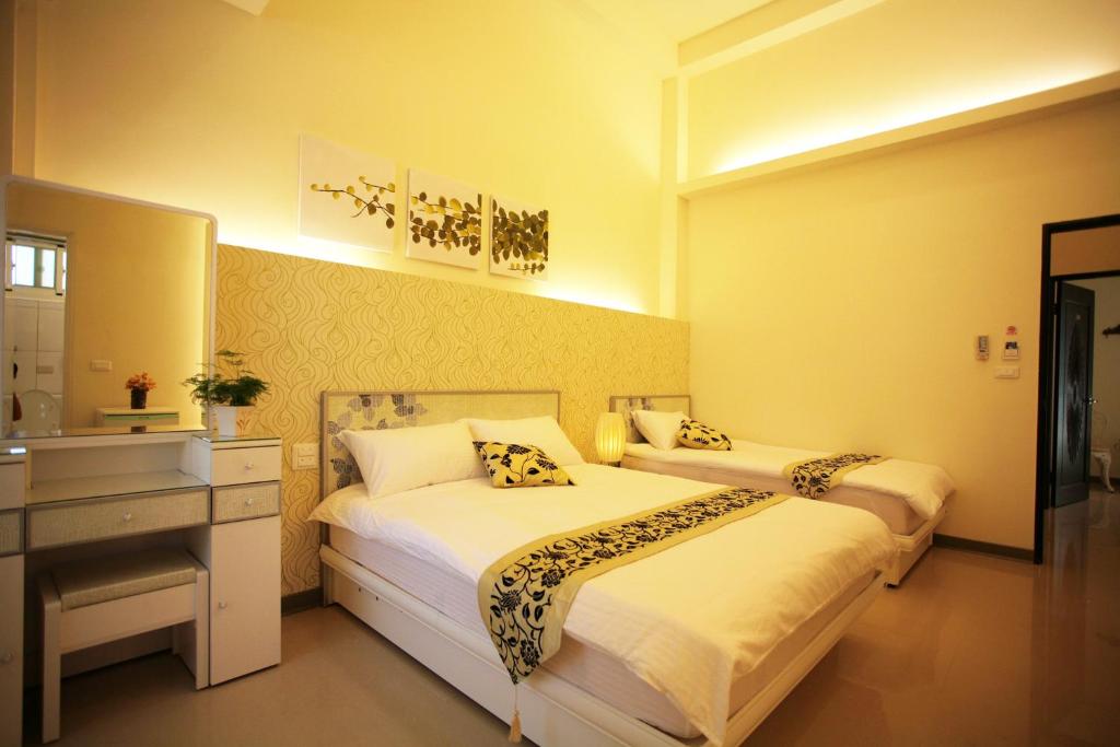 a bedroom with two beds and a dresser in it at Lyon B&B in Hualien City