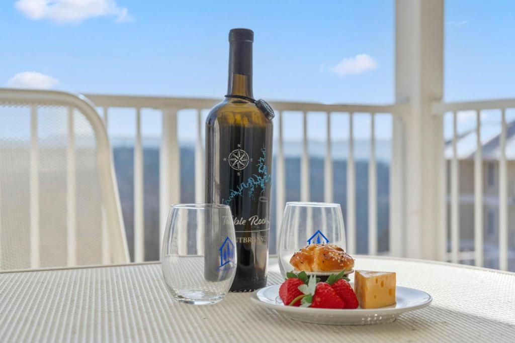 a table with a bottle of wine and a plate of food at Ozark Vista 129 in Kimberling City