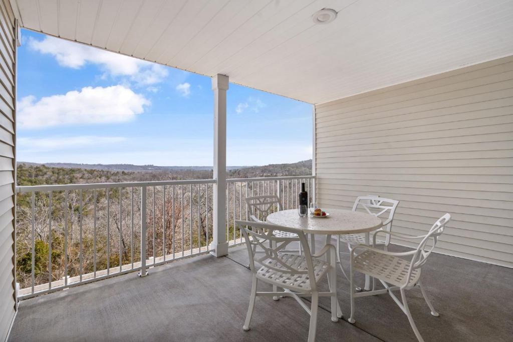 a patio with a table and chairs on a balcony at Large 2 Bed Condo w Beautiful Deck Views-Free Attraction Tickets-Table Rock Lake Access in Kimberling City