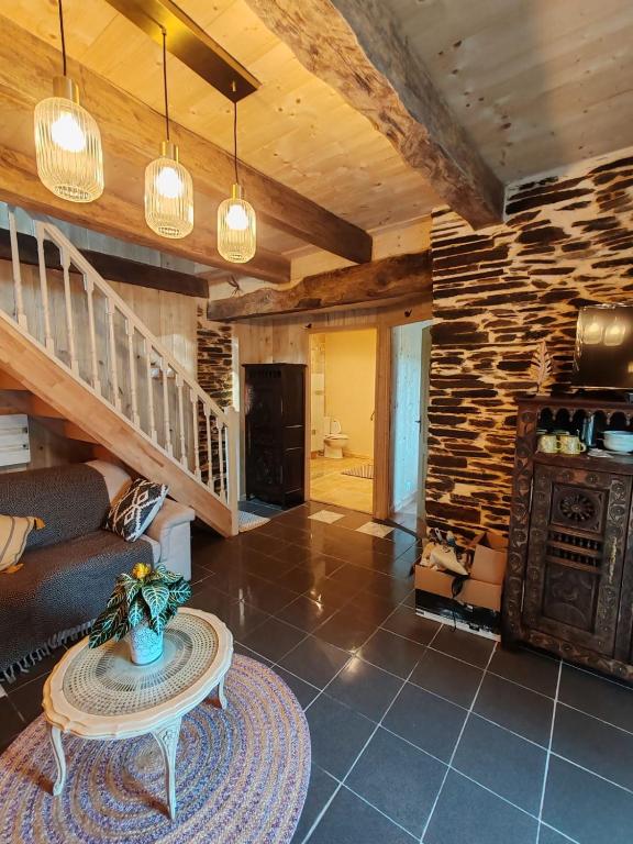 un salon avec une table et un mur en pierre dans l'établissement ar wezenn gozh, à Laniscat