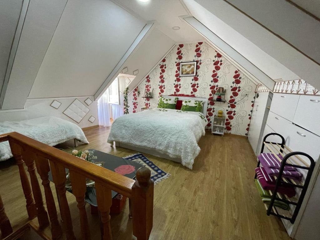 un dormitorio en el ático con una cama y una escalera en Alma apartament, en Tiflis