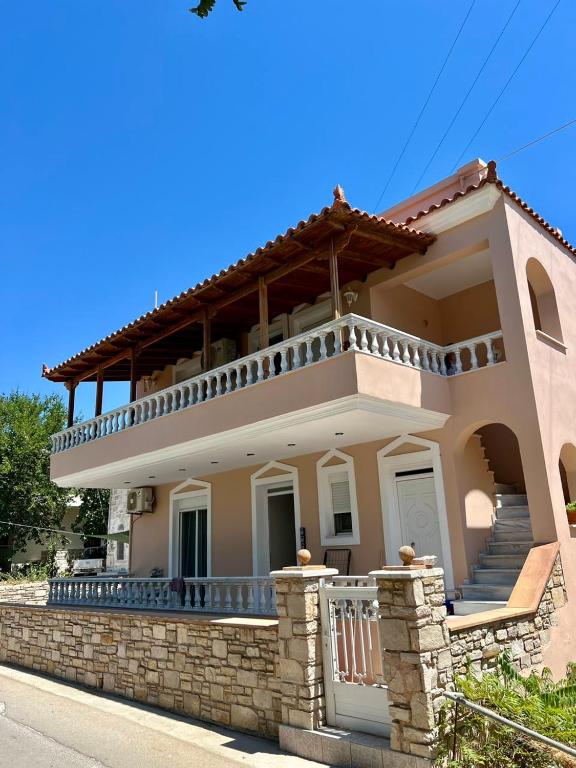 a large house with a balcony on a stone wall at Komi's Pink Paradise 1 in Kómi