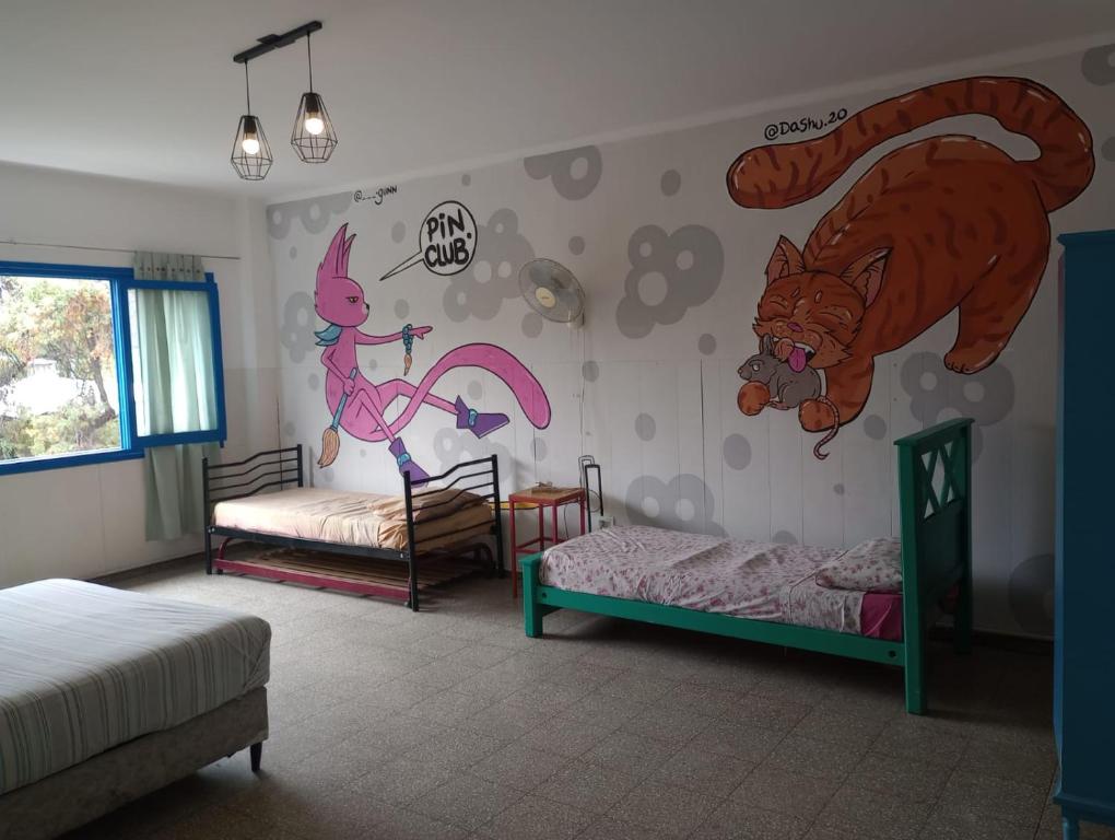 1 dormitorio con 2 camas y un mural de un oso y un zorro en Hostel Rafa, en Mendoza