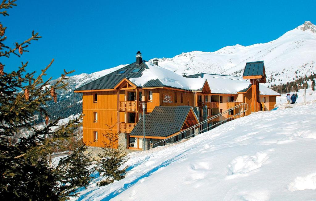 a large building on top of a snow covered mountain at Résidence Odalys Belle Vue in Saint-François-Longchamp