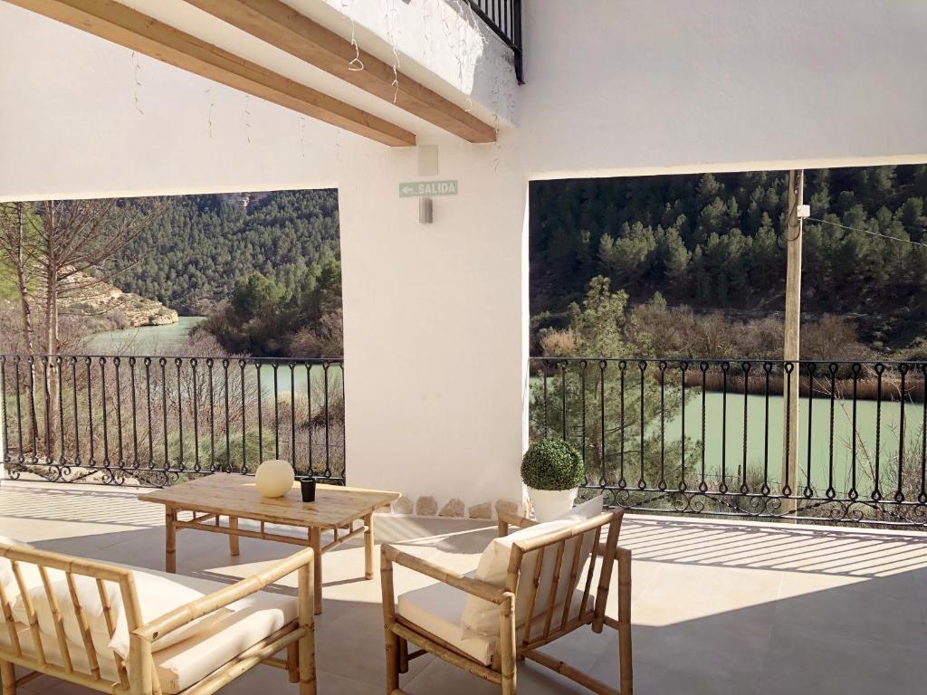 a patio with two chairs and a table and a large window at Casas Lacambra 7DORMITORIOS con piscina, barbacoa y vistas espectaculares in Tolosa