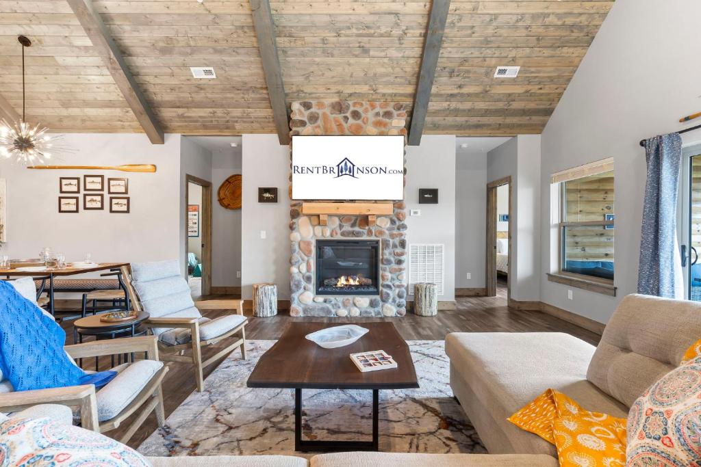 a living room with a fireplace and a table at New Log Cabin, Free Local Attraction Tickets Daily, Ozark Views, Cmty Amenities! in Branson
