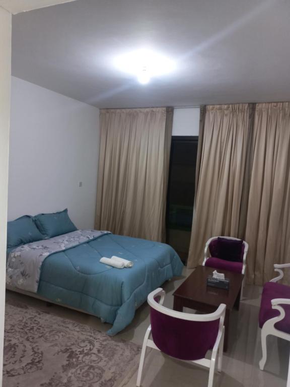 a bedroom with a bed and a table and chairs at QUATRO #My H0ME #4 in Abu Dhabi