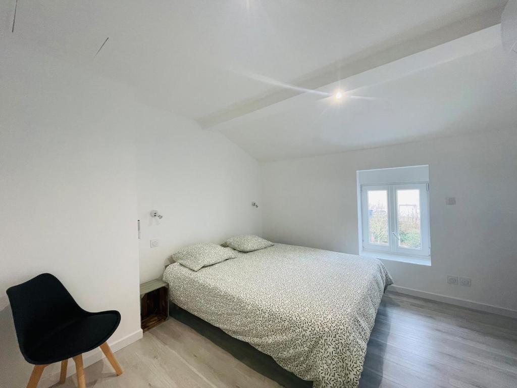 a white bedroom with a bed and a chair at Éclat St Romain n3, duplex - moderne - WIFI - CLIM- proche Vienne in Saint-Romain-en-Gal