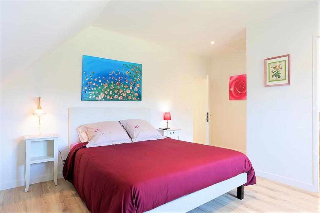 ein Schlafzimmer mit einem roten Bett mit einem Gemälde an der Wand in der Unterkunft Chambres indépendantes de charme à proximité d'Amboise in Pocé-sur-Cisse