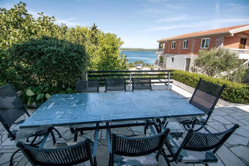 a table and chairs on a patio with a view of the water at Holiday home in Tkon - Insel Pasman 6922 in Tkon