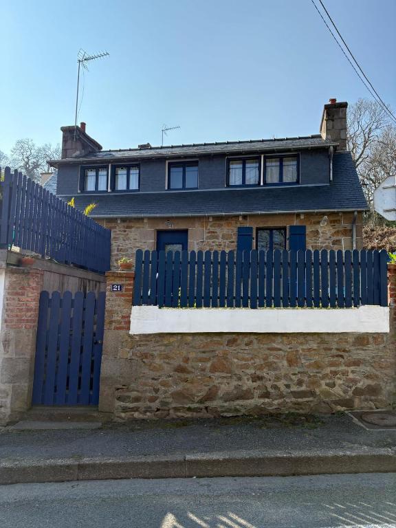 une clôture bleue devant une maison en briques dans l'établissement Maison de pêcheur, à Perros-Guirec