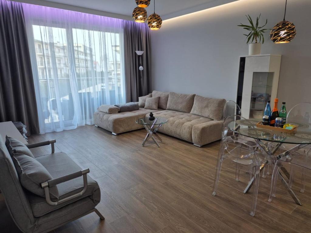 un soggiorno con un divano e un tavolo di vetro di REKO apartament z basenem i SPA tuż przy plaży a Rewal