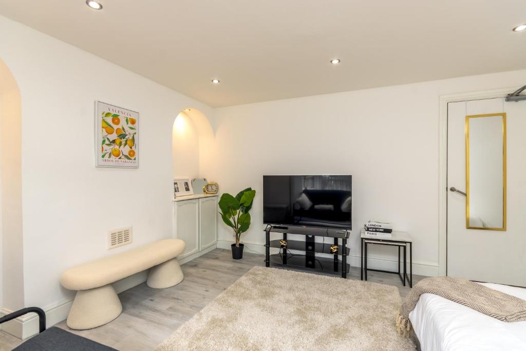 a white living room with a bed and a tv at Luxury Studio with Free Parking in Nottingham