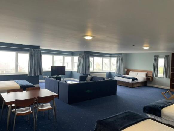 a hotel room with a couch and a bed at Inn On The Coast in Portrush