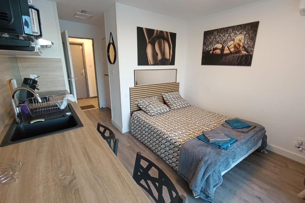 une chambre avec un lit et une télévision dans une pièce dans l'établissement Naturiste Cap d'Agde Port Vénus 211, au Cap d'Agde