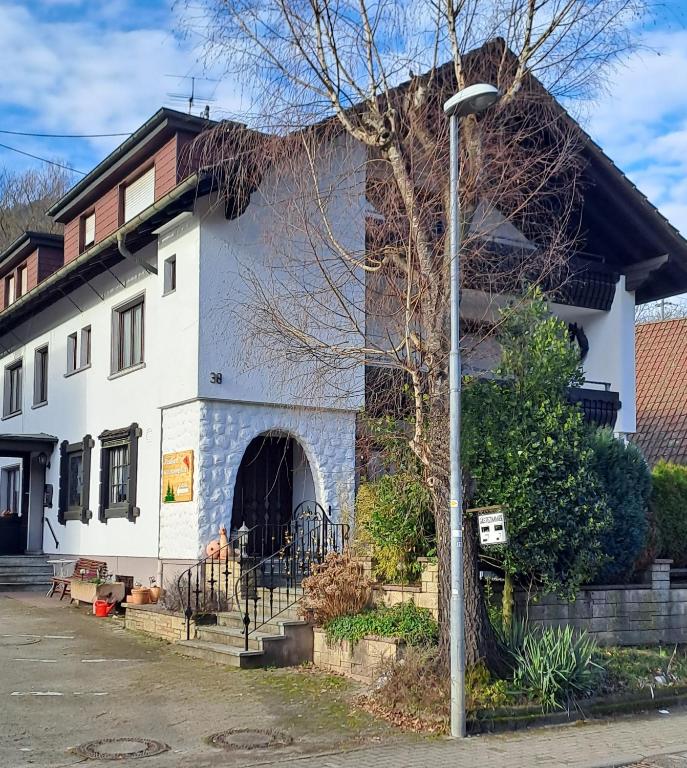 a white building with a street light in front of it at Pension Schlossbergblick in Simonswald