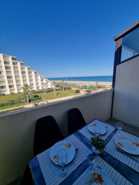 une table sur un balcon avec vue sur la plage dans l'établissement Vue magnifique, Appt 5 couchages, Clim, Secteur Lydia Grande Plage, au Barcarès
