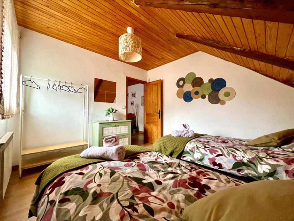 a bedroom with two beds and a wooden ceiling at Apartamento La Buhardilla del Boscache in San Juan de Plan
