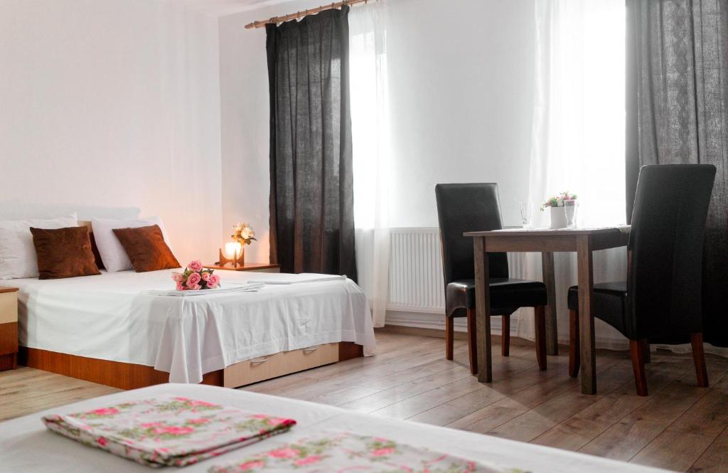 ein Hotelzimmer mit einem Bett und einem Tisch und Stühlen in der Unterkunft ,, LA MAISON CONCORDIA '' in Cincu