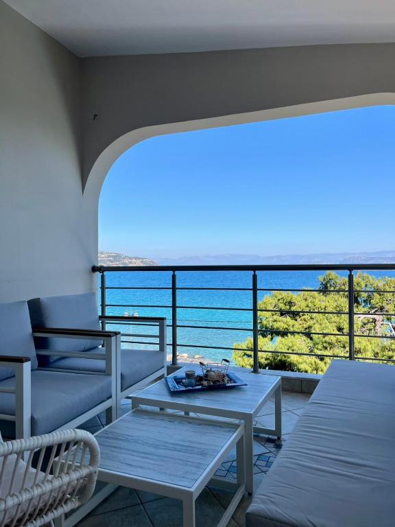 a balcony with a table and a view of the ocean at EVITA PHILOXENIA in Xiropigado