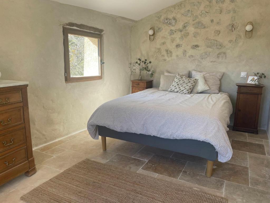 une chambre avec un lit et une fenêtre dans l'établissement La Maison de Vergol, à Montbrun-les-Bains