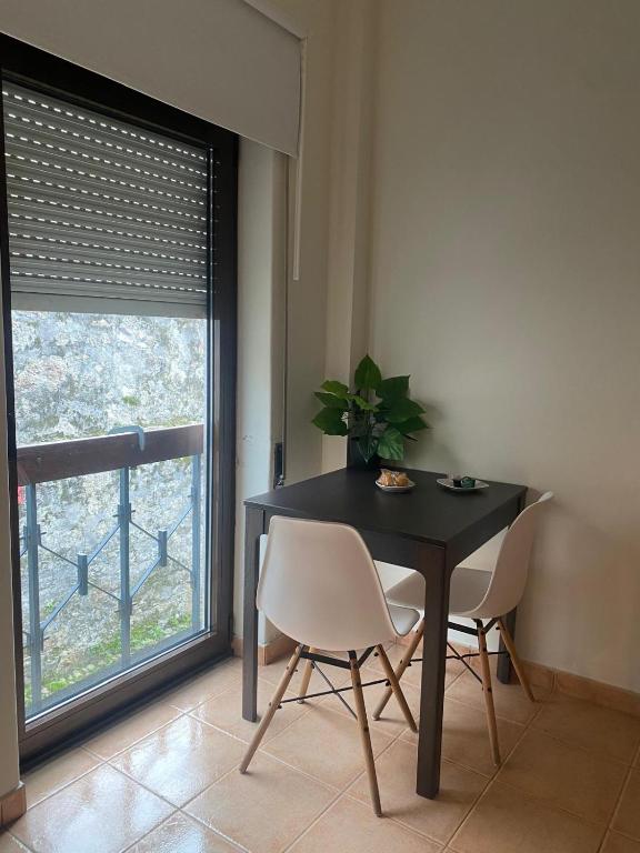 a dining room with a table and chairs and a window at Cici Guesthouse in Caminha