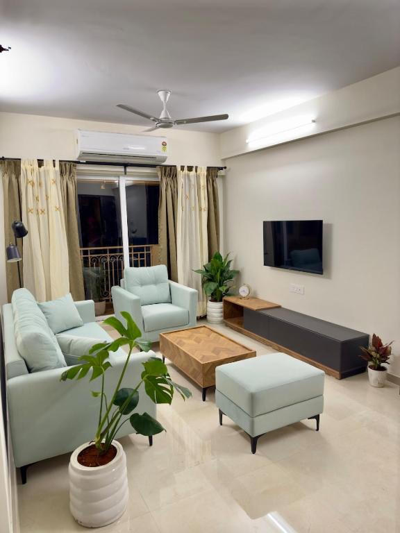 a living room with two couches and a tv at Your Ultimate Edge Awaits! in Thane