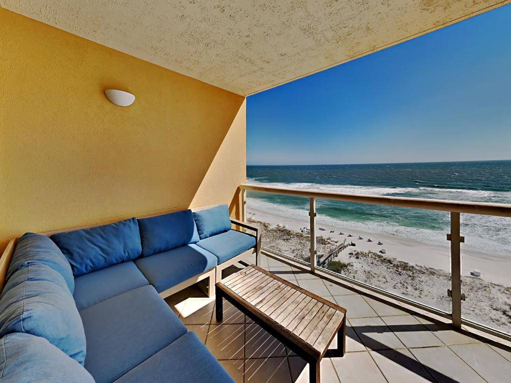 sala de estar con sofá azul y vistas a la playa en Emerald Isle #1108 - Emerald Dreams, en Pensacola Beach